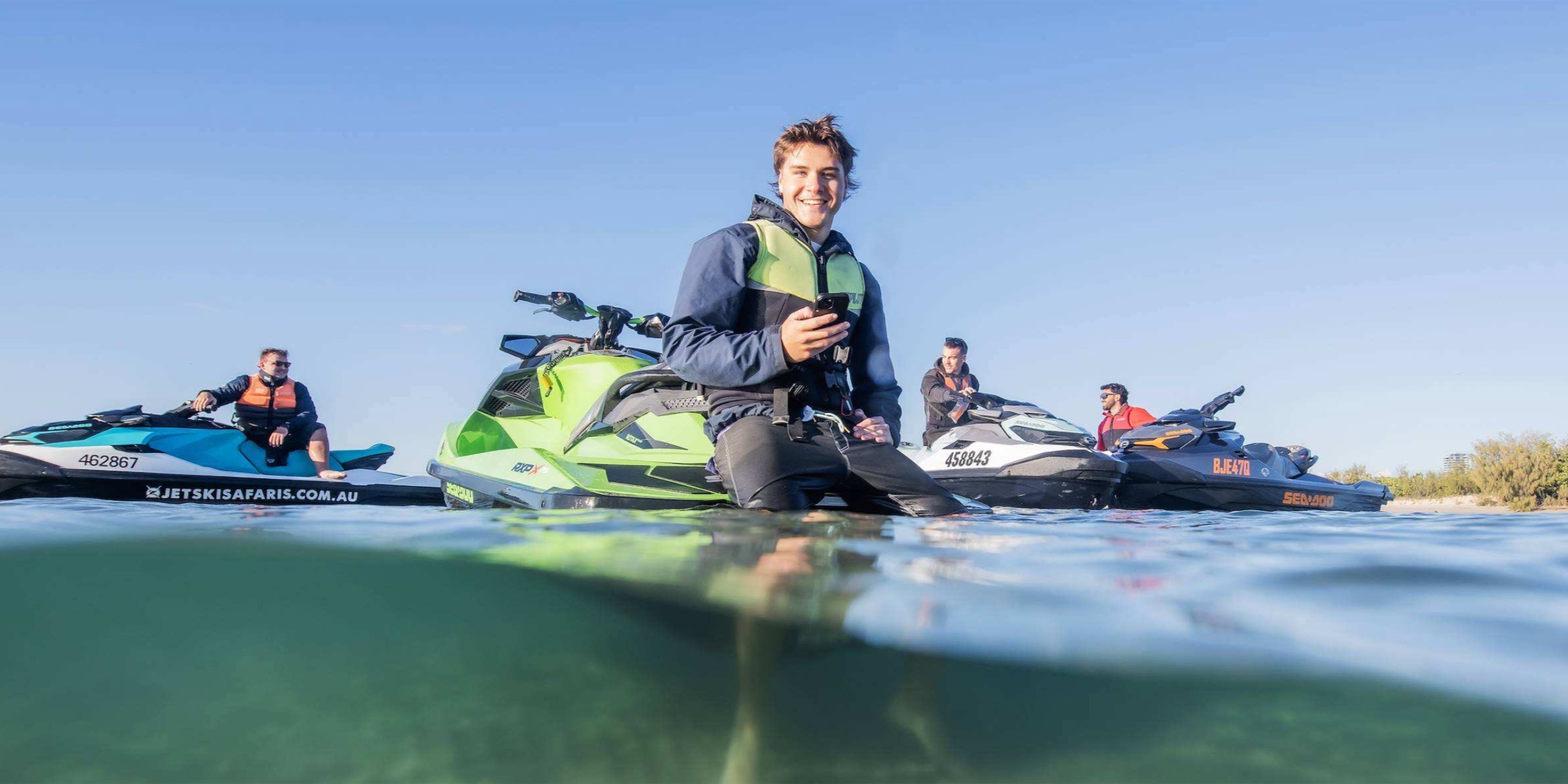 Four riders on their jet skis together in the shallows